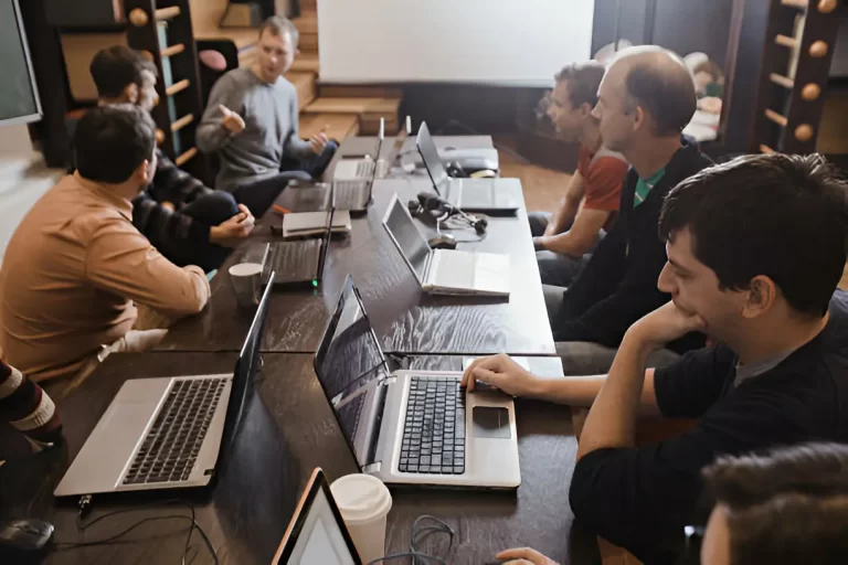 People discussing with laptops